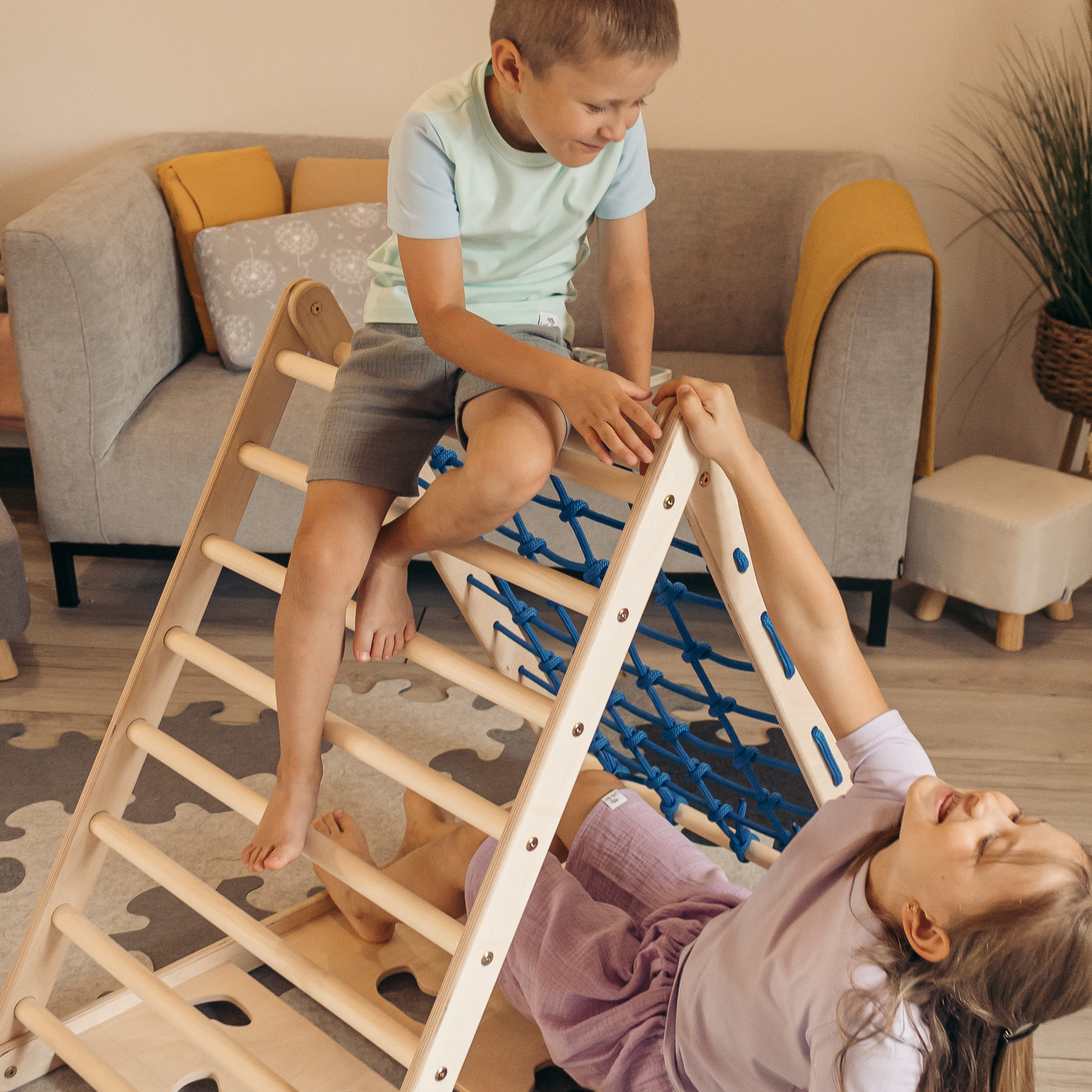 Motorische Entwicklung von Kindern: Kinder trainieren spielerisch ihr Gleichgewicht auf dem Pikler-Kletterdreieck Tigerfels XL